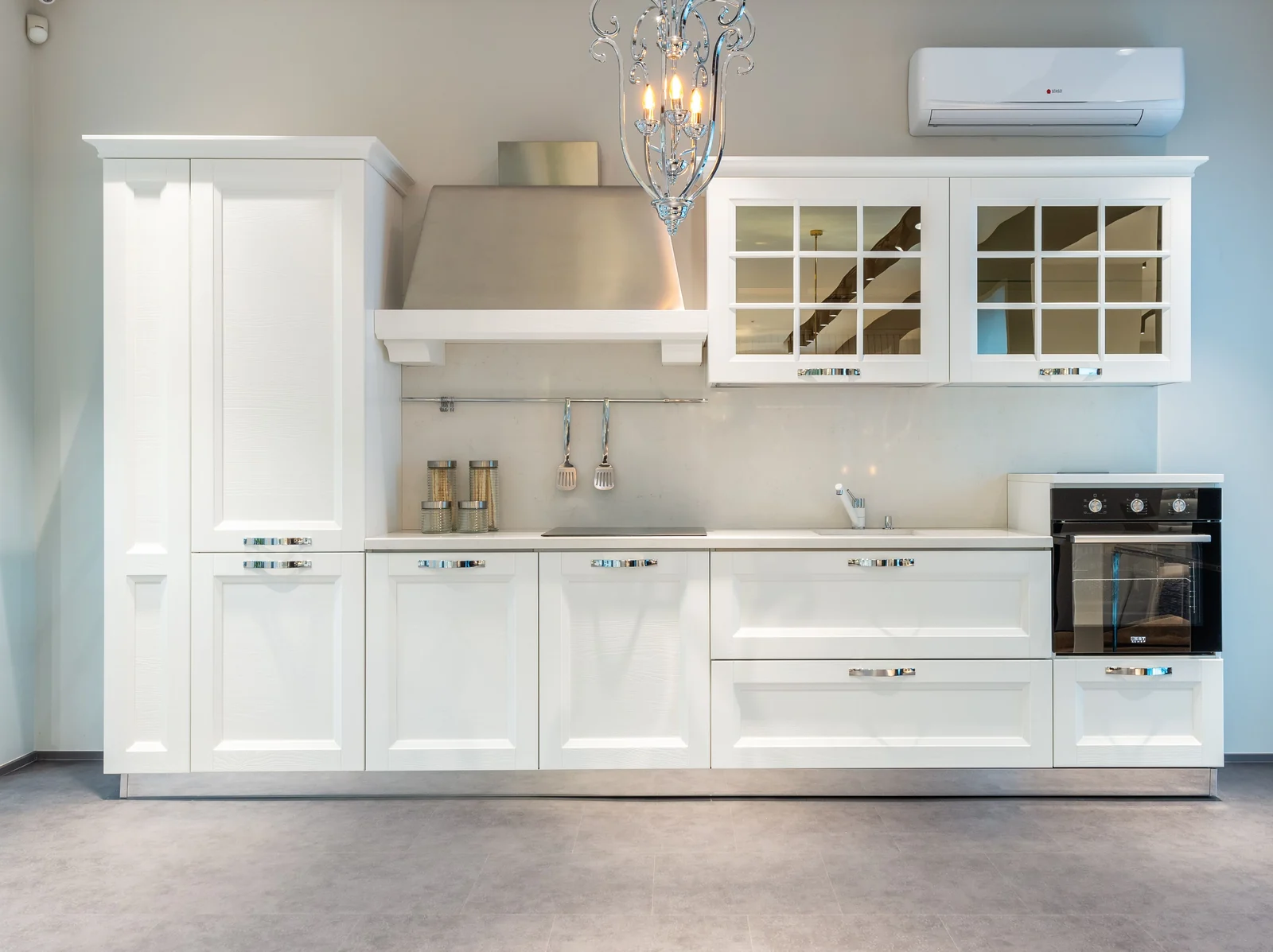 A white shaker run with glass upper doors and a chimney hood